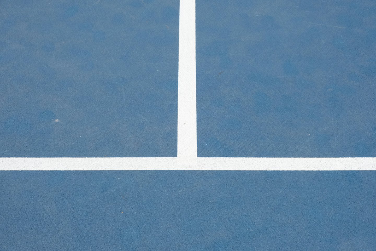 White boundary lines painted on a blue sports court surface.